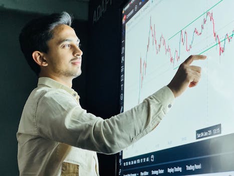 Home Man analyzing stock market graph on a digital board with a focused expression.